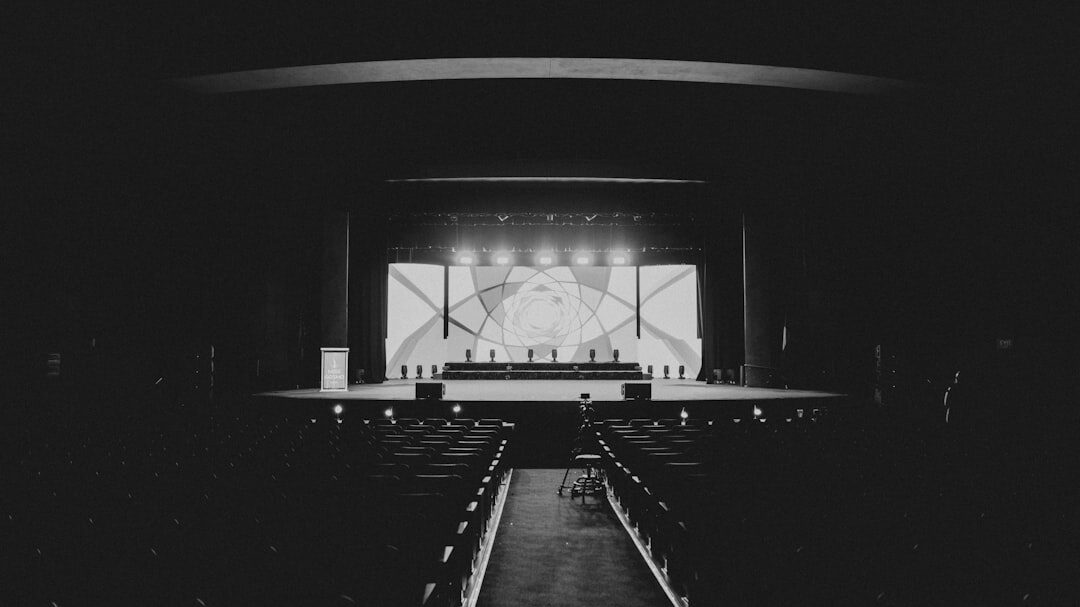 Single warm spotlight beam on an empty dark stage