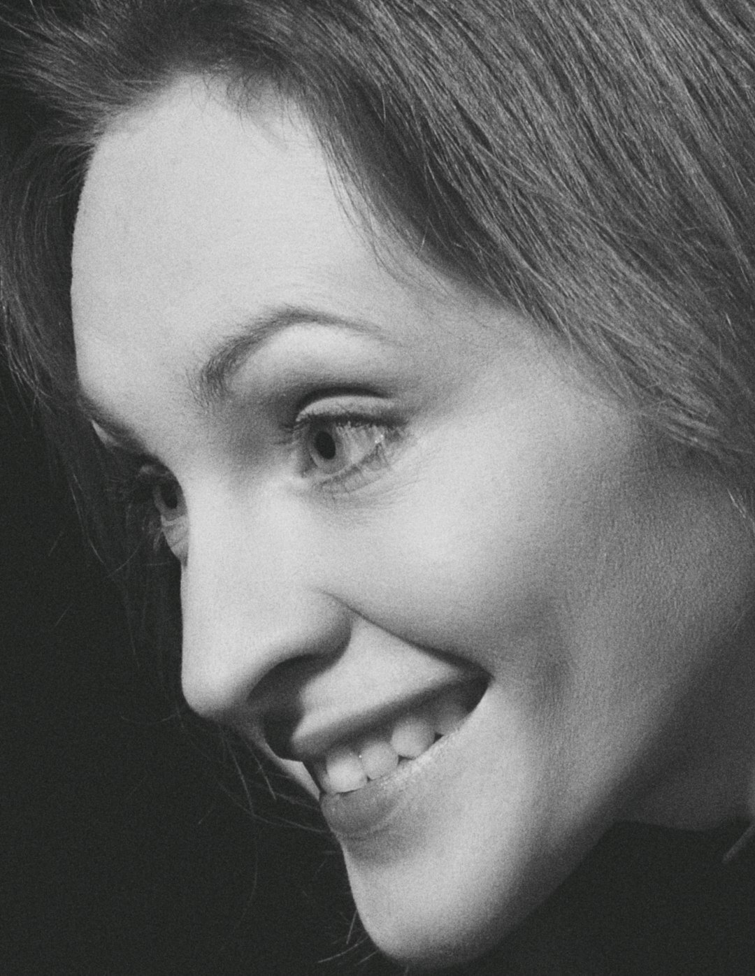 Studio portrait of a smiling woman with brown hair