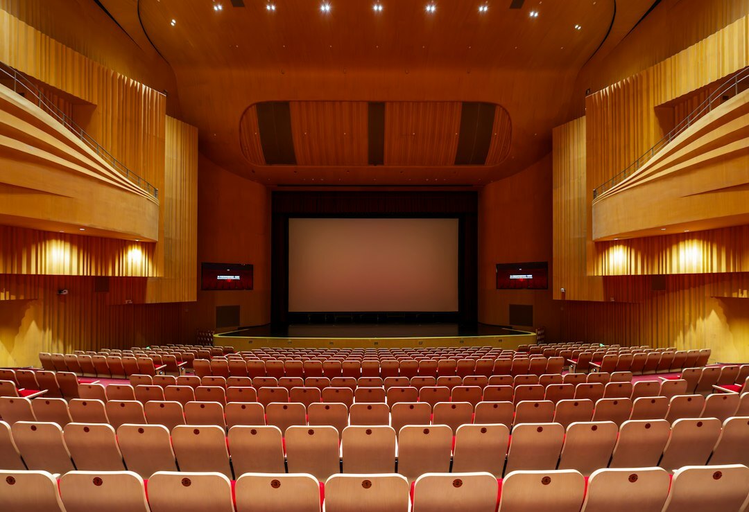 Rows of empty red seats in a classic theatre auditorium